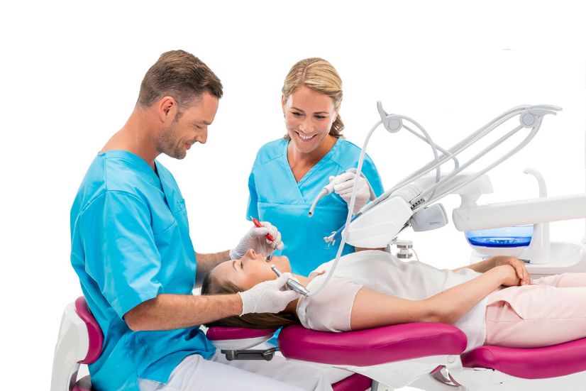 En tandlæge og en klinikassistent er i gang med en behandling hvor man kan se at der er god plads til begge to omkring tandlægeunitten